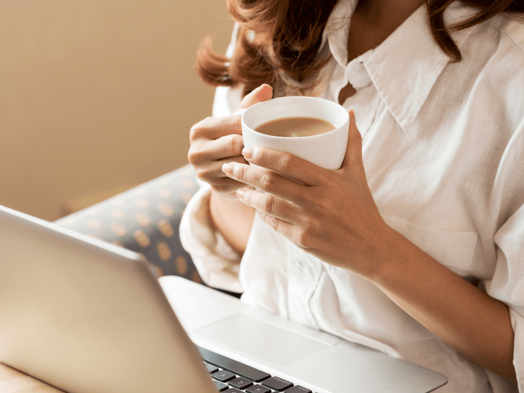 femeie la laptop cu cafea